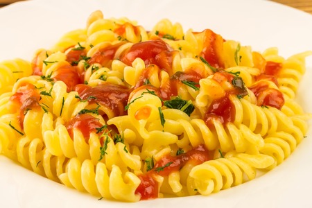 Italian pasta fusilli with tomato sauce in plate, close-up view.の写真素材