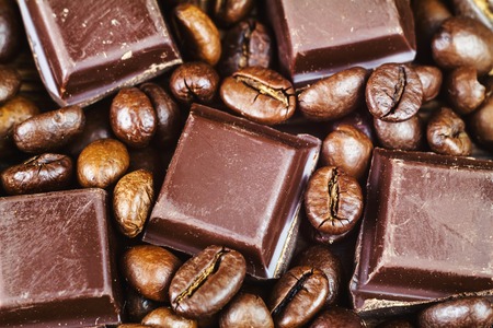 Dark chocolate cubes and roasted coffee beans, close-up, top view, selective focusの写真素材
