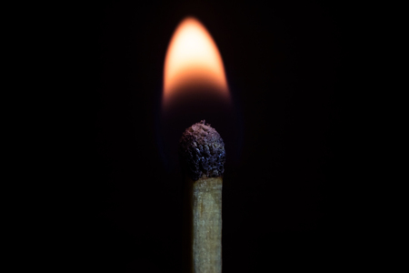 Burning match isolated on a black background, macro imageの写真素材