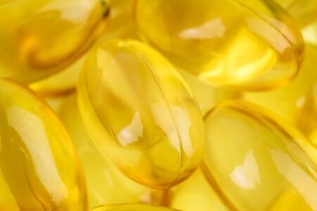 Natural food supplement, yellow gel pills Vitamin E capsules, macro image