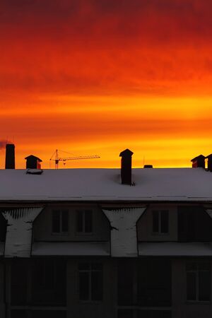Red, orange, vivid sky at sunrise over the building in the cityの写真素材