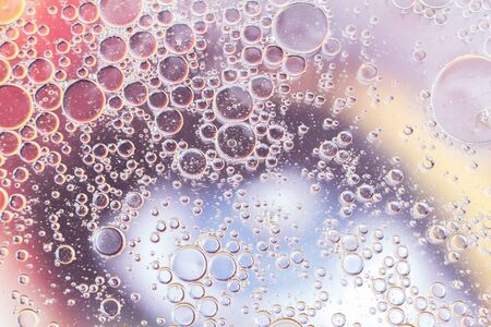 Oil drops floating in water abstract multi color background
