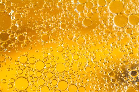 Oil drops floating in water abstract orange color backgroundの写真素材