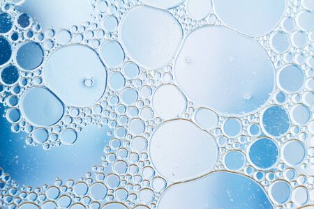 Oil drops floating in water abstract blue color background