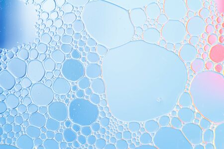 Oil drops floating in water abstract blue color background