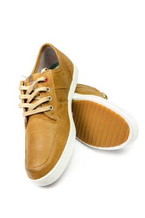 Pair of tan color, leather sneakers isolated on white backgroundの写真素材