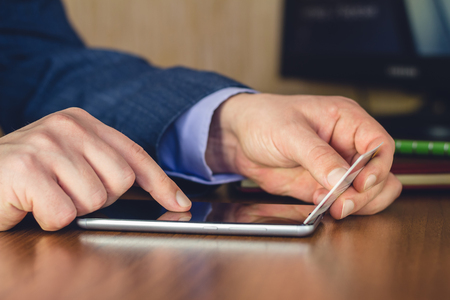 Formal wear, man hands using smartphone and holding credit card for online shopping and payment, selective focusの写真素材