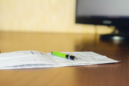 Papper document on table, workplace with focus on pen