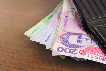 Wallet with ukrainian money currency hryvnia on wooden backgroundの写真素材