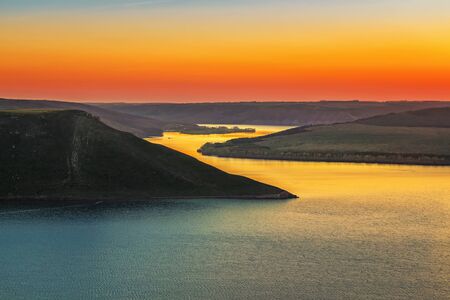 Magnificent sunset scenery on the Dniester canyon and curves river with colorful evening sky reflected in the waterの写真素材