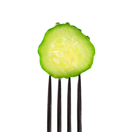 Slice cucumber impaled on fork isolated on white background, close-up view,
