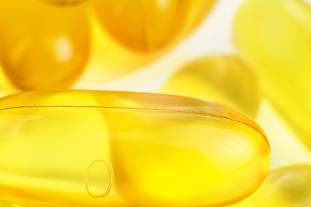 Yellow capsules omega 3, fatty acid, fish oil on heap, macro image.の写真素材