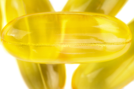 Yellow capsules omega 3, fatty acid, fish oil on heap, macro image.の写真素材