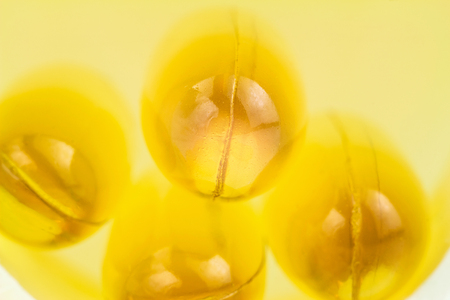Yellow capsules omega 3, fatty acid, fish oil on heap, macro image.の写真素材
