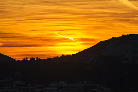 Golden sunset sky at the sea and mountains silhouette.の写真素材