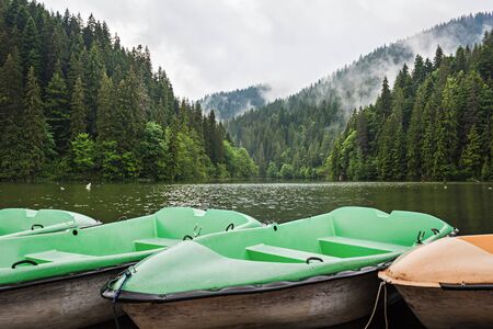 Mountain lake scenery, Lacu Rosu or Red lake with boats near the shore, Eastern Carpathians, Romania, nature landscape background.の写真素材