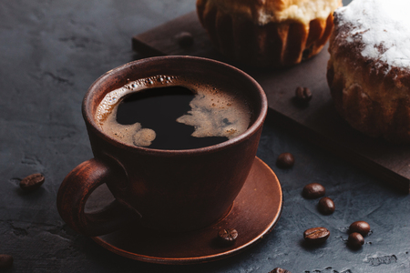Coffee cup and muffins on the dark, textured background.の写真素材