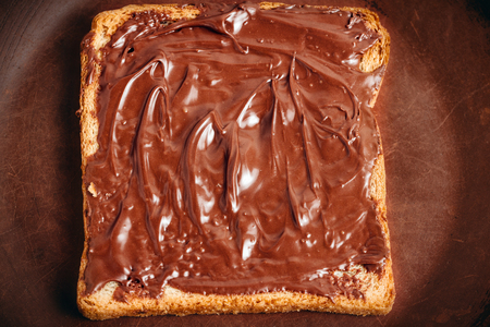 Toast with chocolate hazelnut cream in a brown plate.の写真素材
