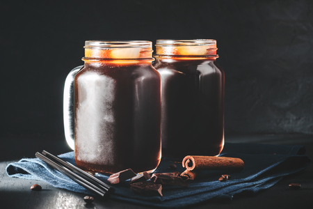 Coffee with ice in a glass mason jars on the napkin at dark background.の写真素材