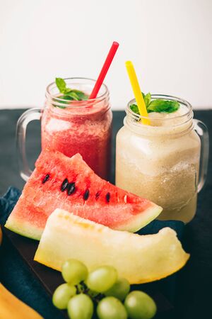 Smoothie from melon and watermelon in a jars with fresh mint leaves and grape.の写真素材