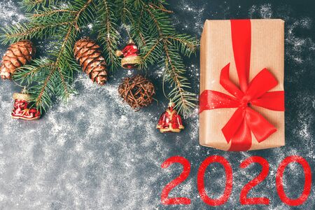 2020 New Year dark background concept, gift box and pine branch with decorations, top view with copy space.の写真素材