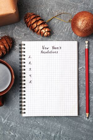 New Year's resolution, text in notepad, promises concept, pencil, coffee cup, decorations, top view.の写真素材