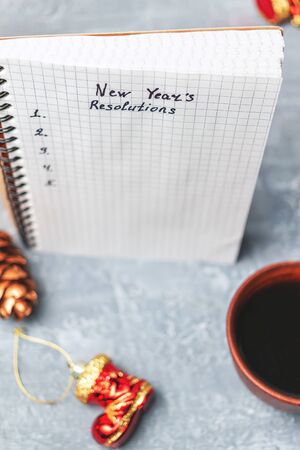 New Year's resolution, text on the paper in notepad, promises concept, coffee cup, decorations.の写真素材