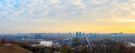 Panorama of Kyiv city and Dnipro river at sunrise in dawn, panoramic view to the colorful autumn...
