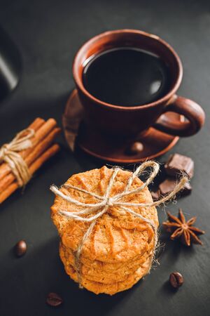 Homemade cookies and brown cup with coffee on dark background.の写真素材