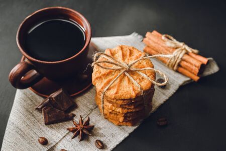 Homemade cookies and brown cup with coffee on dark background.の写真素材