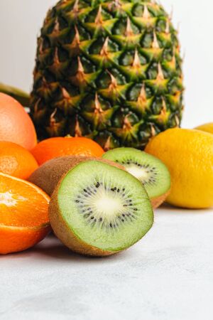 Kiwi and orange sliced halves, tropical fruits on textured white background.の写真素材
