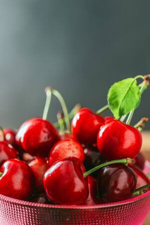 Fresh red cherries in bowl close-up view with copy space.の写真素材