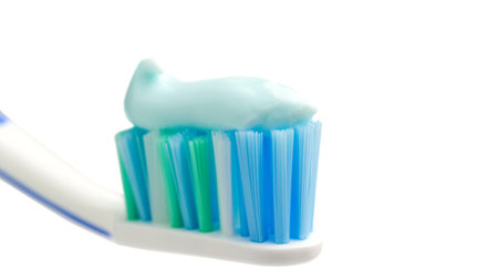 Toothbrush head with toothpaste, close-up view, isolated on white background, macro.の写真素材