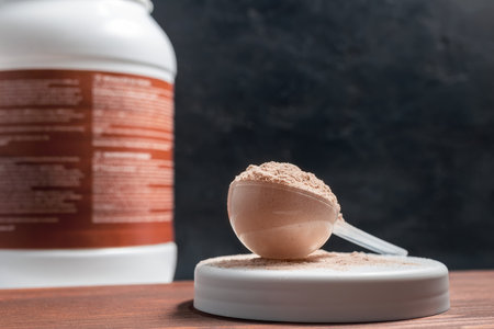 Scoop of whey or soy protein isolate on wooden table, dark background.の写真素材