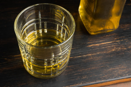 Glass with alcoholic drink, whiskey, brandy, rum on a wooden table.の写真素材