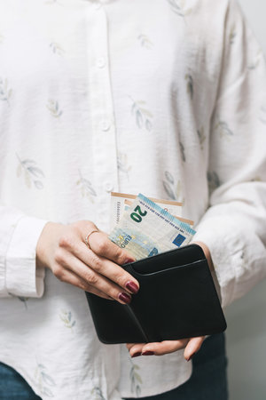 Woman's hands taking out money from wallet, euro banknote cash.の写真素材