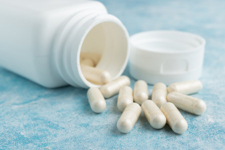 White medical capsules, pills or drugs for treatment on blue background, vitamins and minerals, nutritional or dietary supplement.の写真素材