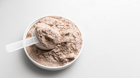 Whey protein powder in measuring scoop.