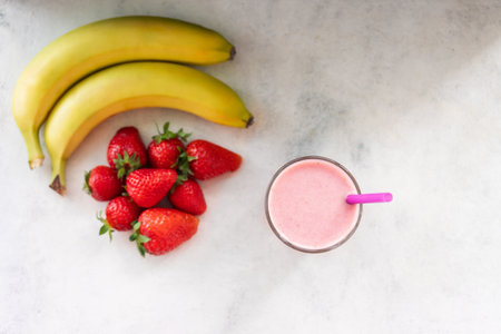 Strawberry and banana smoothie drink, blended cocktail, milkshake in a glass, top view.の写真素材