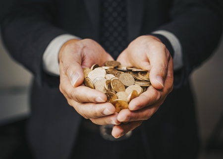 A coins in people hands in saving money conceptの写真素材