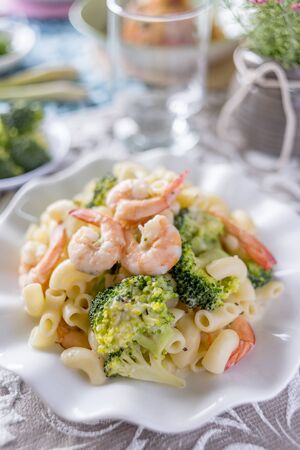Italian pasta fettuccine in a creamy sauce with shrimp on a plate.の写真素材