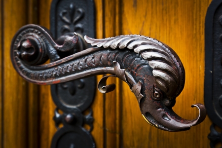 Decorative antique door handles with fish pattern on a big chatedralの写真素材