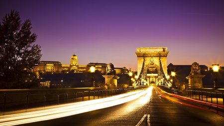 The lit  of the Szechenyi Chain Bridge is a suspension bridge that spans the River Danube of the beautiful, decorative Budapest, the capital city of Hungary at nightの写真素材