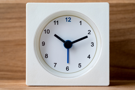 White clock with vintage wooden background