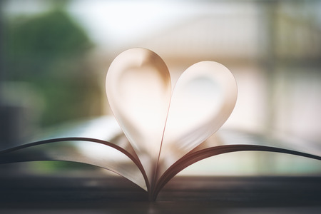 Open book with pages forming heart shape with feeling love and romanceの写真素材