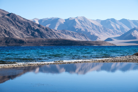 Landscape reflection image of Pangong lake with mountains view and blue sky backgroundの写真素材