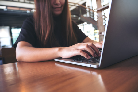 Closeup image of a beautiful Asian business woman looking , working and typing on laptop keyboard in officeの写真素材