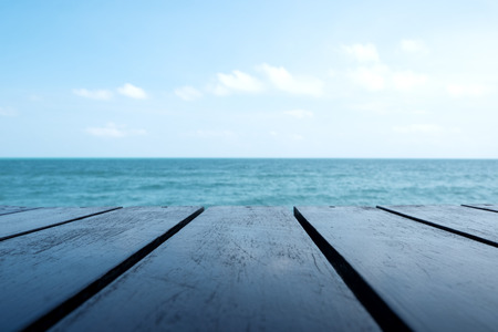 Wooden table with the sea and blue sky backgroundの写真素材