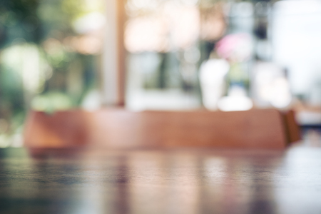 Blur image of wooden table and chairs in modern cafe with bokeh background