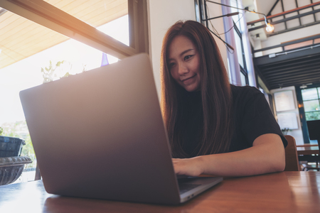 Closeup image of a beautiful Asian business woman looking , working and typing on laptop keyboard in officeの写真素材